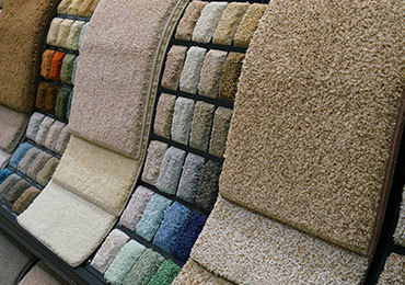 A wide variety of carpet texture and color samples displayed on racks in a flooring showroom.