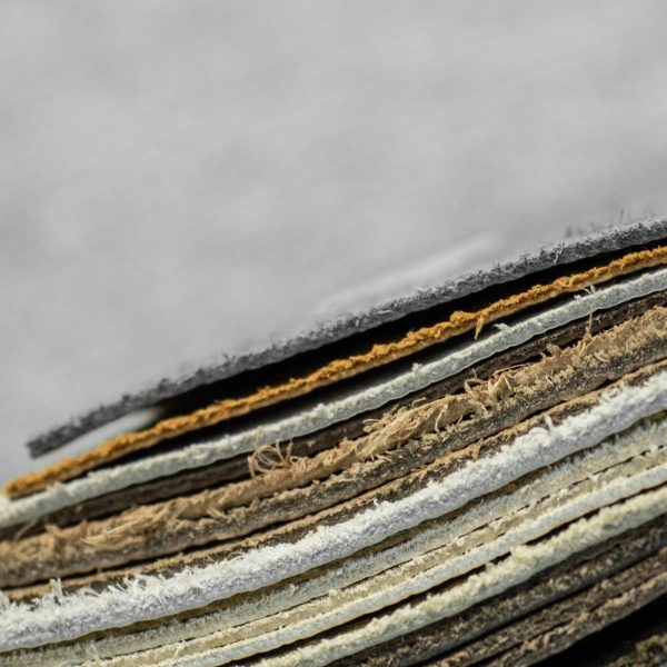 A close-up of stacked layers of material in various colors, showcasing textures and edges against a blurred background. A close-up of stacked layers of material in various colors, showcasing textures and edges against a blurred background.